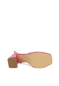 Scarpa con tacco alto rosa dal rivestimento liscio, punta quadrata e tacco grosso. Presenta un sottile dettaglio a fiocco sul tallone e una suola piatta e testurizzata.