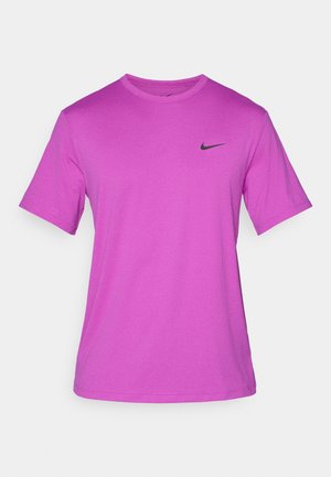 Lilla kortærmet T-shirt lavet af et glat stof, med et sort Nike-logo på venstre brystområde. Klassisk rund hals.