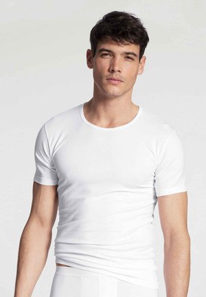 T-shirt blanc à manches courtes en tissu doux et extensible. Il dispose d'un col rond et d'un design ajusté. Texture lisse.