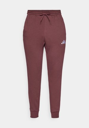 Pantalons de survêtement bordeaux en tissu doux, dotés d'une taille élastique avec cordon de serrage et d'un petit logo Adidas bleu sur la cuisse gauche.