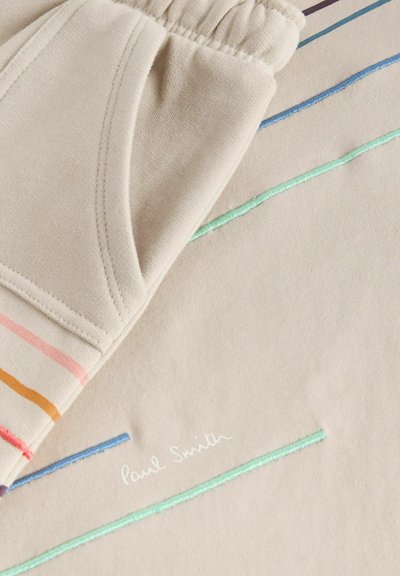 Beige sweatshirttyg med flerfärgade sömmar i ränder, med en känguruficka och broderad "Paul Smith"-logotyp i kursiv.
