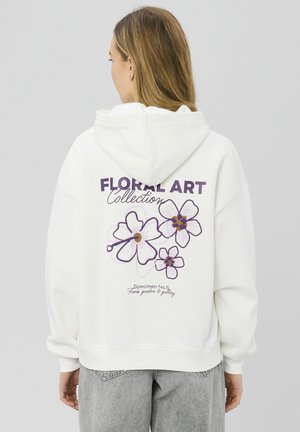 Sweat à capuche blanc avec un motif floral violet, avec le texte "FLORAL ART Collection" et "Specimen No. 5" au dos.