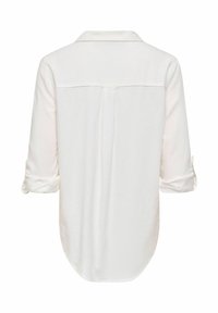 Blouse blanche à manches longues retroussées, avec empiècement dos et pli central, dotée d'un ourlet arrondi.
