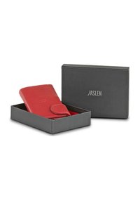 Cartera roja de cuero con cierre de solapa, presentada en una caja negra con un logo. Superficie texturizada, diseño elegante, forma compacta.