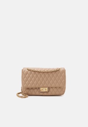 Beige doorgestikte leren handtas met gouden kettingbandje en gouden draaisluiting op een effen lichte achtergrond.