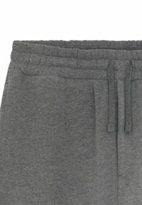 Pantalons de survêtement gris en coton avec une taille élastique, un cordon de serrage et une poche latérale. Texture douce avec un design décontracté.