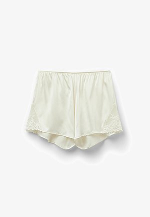 Cream-colored satin shorts with an elastic waistband and lace accents on the sides; smooth texture, relaxed fit, and scalloped hem.