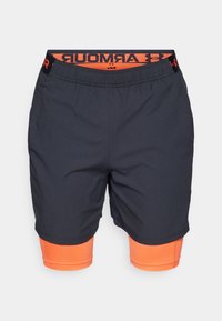 Pantalones cortos deportivos negros con una capa interior y cintura naranja. Presentan una cintura elástica y paneles laterales perforados para mayor transpirabilidad.