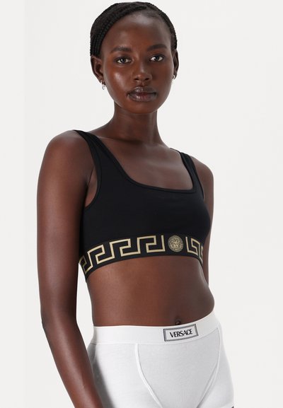 Schwarzer Sport-BH mit goldener griechischer Schlüssel-Musterung und einem Versace-Medaillon am Bund. Weiches Material mit breiten Trägern; schlichtes Design.