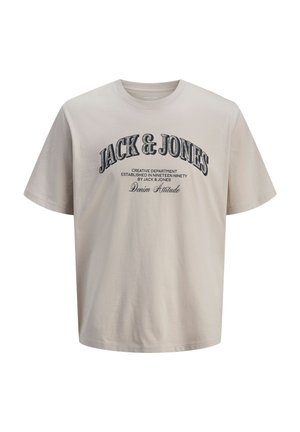 Camiseta beige de algodón con un corte cómodo y relajado. En el frontal presenta un texto en negro intenso: "JACK & JONES" y detalles adicionales de la marca debajo.