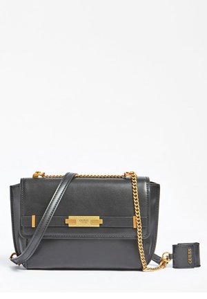Sac à bandoulière Guess en cuir noir avec une chaîne dorée et une plaque logo, accompagné d'une étiquette de bagage amovible assortie.