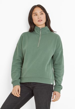 Green fleece pullover with a high collar and quarter zip. Features ribbed hem and cuffs, relaxed fit, and soft texture. Simple, solid color.