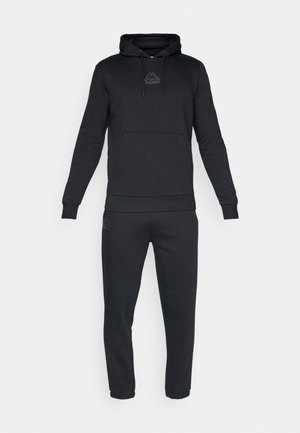 Sort sweatshirt med hætte og frontlomme, med et lille logo. Matchet med sorte joggerbukser med afsluttede ankler og matchende logo.