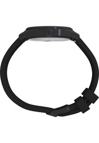 Ceas de mână negru cu o carcasă rotundă, sticlă minerală clară și o curea flexibilă din cauciuc cu cataramă. Detaliu remarcabil cu logo pe lateral.