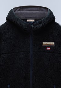 Černá fleecová bunda s kapucí, předním zipem, nášivkou s logem Napapijri Geographic a malou norskou vlajkou na hrudi.