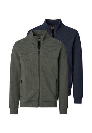 Twee heren truien met volledige ritssluiting en opstaande kragen, één in olijfgroen vooraan en één in marineblauw achteraan, beide met ritssluiting aan de zijkanten.