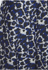 Sinine, must ja valge loomaärimustriga kangas, millel on sile tekstuur ja abstraktne muster, sisaldades ebaühtlasi kujundeid ja laike.