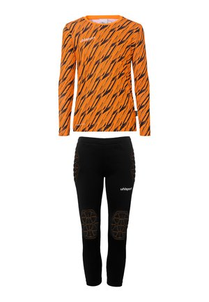 Chemise orange à manches longues avec des rayures en zigzag noires et un logo, accompagnée d'un pantalon noir ajusté avec des accents de genoux rembourrés et un logo.