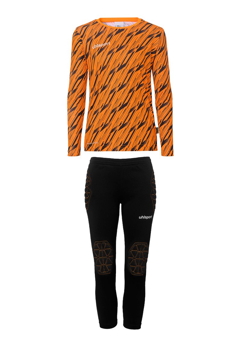 Chemise orange à manches longues avec des rayures en zigzag noires et un logo, accompagnée d'un pantalon noir ajusté avec des accents de genoux rembourrés et un logo.