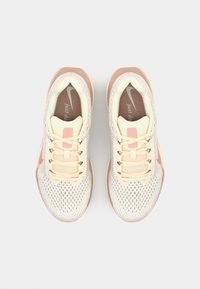 Lichtbeige sport schoenen met een bovenkant van mesh, crèmekleurige accenten, roze logo en een gegroefde zool. Voorzien van platte veters en een gewatteerde tong.