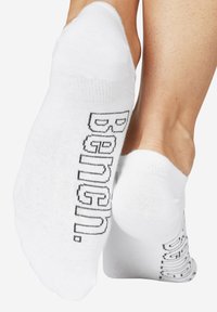 Weiße Baumwollknöchelsocken mit schwarzer Schrift an der Seite. Das Design zeichnet sich durch eine weiche, glatte Textur und eine enge Passform aus.