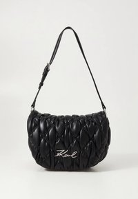 Black quilted handbag with a rounded shape, made of leather, featuring silver hardware and a branded logo on the front. Adjustable strap.