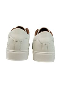 Sneaker bianche in pelle con una texture liscia, con retro arrotondato e dettagli marroni sul tallone. Suola piatta in gomma con grip a motivo.