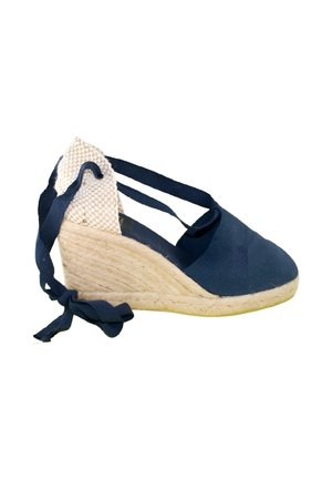 Alpargata cuña azul marino con tacón de yute tejido y tiras para atar al tobillo sobre fondo blanco
