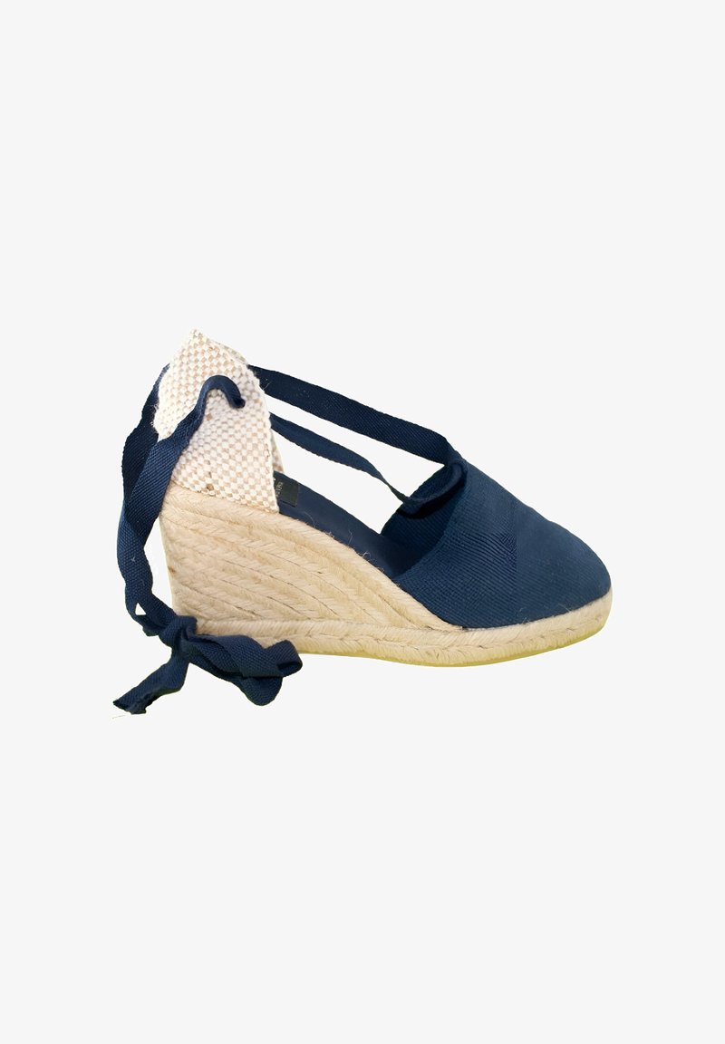 Alpargata cuña azul marino con tacón de yute tejido y tiras para atar al tobillo sobre fondo blanco