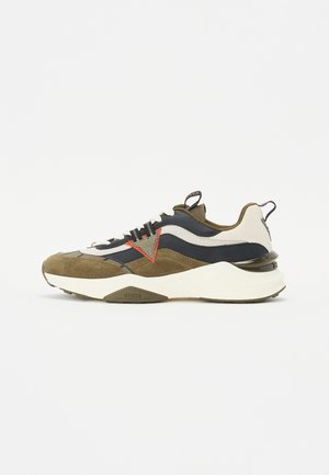 Sneaker with a mixed material design featuring suede in olive green and navy, white mesh accents, a red logo detail, and a chunky white sole.