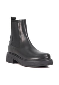 Zwarte leren Chelsea boots met een ronde neus, elastieken zijkanten en een dikke zwarte rubberen zool. Voorzien van een trekkoord voor gemakkelijk aan- en uittrekken.