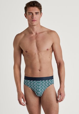 Zwemslips in marineblauw met een geometrisch patroon in groen en wit. Gemaakt van rekbare stof, met een gladde tailleband.