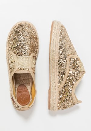 Glitrende guld-sko med et tekstureret design, rund form, elastiske snørebånd og en vævet jutesål. Glat beige foring indeni.