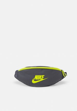 Ciemnoszara nerka Nike z neonowożółtym zamkiem i logo, kompaktowa i zaokrąglona, zaprojektowana do noszenia bez użycia rąk.