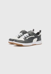 Chaussures de sport avec un dessus synthétique gris, des accents blancs et des bandelettes auto-agrippantes. Elles présentent une semelle en caoutchouc blanc avec une semelle extérieure en caoutchouc naturel.