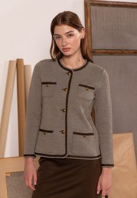 Texturerad grå kavaj med fiskbensmönster och bruna detaljer, med guldfärgade knappar och två fickor framtill, rund halsringning och figursydd passform.