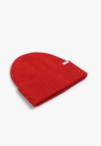Gorro de punto rojo, con textura acanalada y puño doblado. Pequeña etiqueta de la marca visible en el lateral. Material de tela suave.