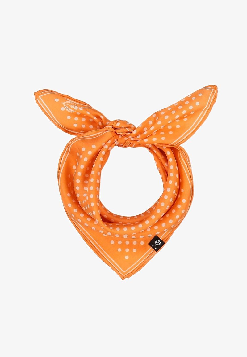 Foulard en soie orange à pois blancs noué, comportant une petite étiquette noire sur un coin.