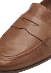 Brown leather loafer with a smooth texture, featuring a top strap and subtle stitching details, rounded toe, and a low profile sole.