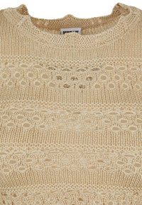 Strikket beige genser med et teksturert m�ønster og åpne detaljer. Rund hals og litt bølgete kanter. Lett materiale.