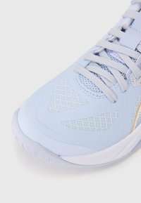 Light blue athletic shoe with mesh and synthetic materials, featuring textured accents and a lace-up design. Curved rubber sole.