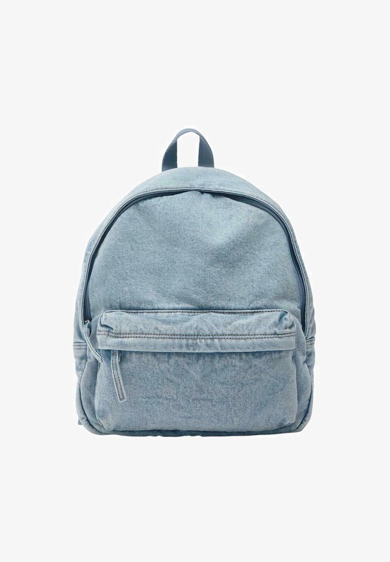 Sac à dos en jean bleu clair avec une poche avant zippée et une poignée de transport supérieure, présenté sur un fond blanc.
