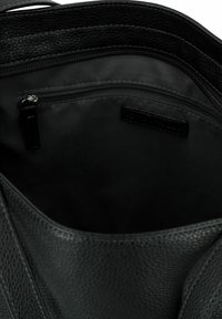 Sac à main en cuir noir avec un extérieur texturé. L'intérieur présente une doublure en tissu lisse et une poche zippée pour un rangement sécurisé.