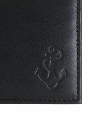 Surface en cuir noir avec des bords cousus, comportant un symbole d'ancre embossé dans le coin inférieur droit.