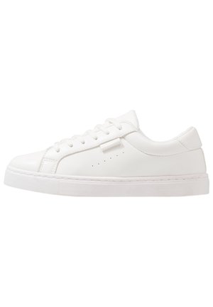 Hvit sneakers med en glatt, syntetisk overdel, rund tå, flate lisser og perforerte detaljer på sidene. Standard gummisåle.