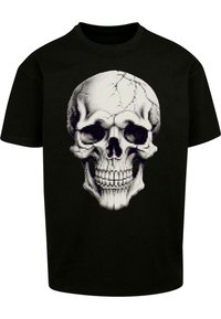 Sort bomulds t-shirt med et detaljeret hvidt kraniegrafik med et pixeliseret udseende og revnet tekstur på kraniedesignet.