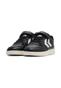 Schwarze Sportschuhe mit einer glatten Lederoberfläche, die weiße Streifen an den Seiten und Schnürsenkel für eine sichere Befestigung aufweisen.