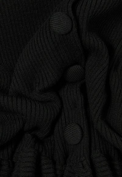 Tessuto a maglia nero a costine con bottoni rotondi texturizzati abbinati disposti verticalmente su materiale arricciato.