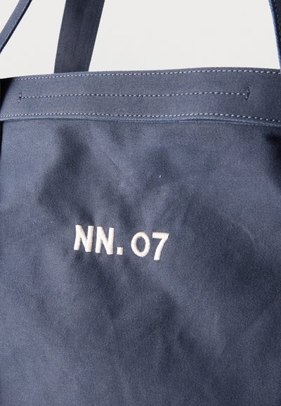 Τσαντάκι από ύφασμα σε ναυτικό μπλε με λευκό ραμμένο λογότυπο «NN. 07», με δύο χερούλια και εμφανή ραφή στην πάνω πλευρά.