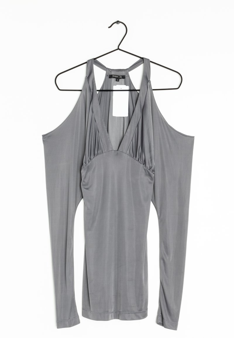 Robe grise sans manches avec un décolleté en V profond et des panneaux de tissu drapés étendus suspendus aux épaules sur un cintre noir.